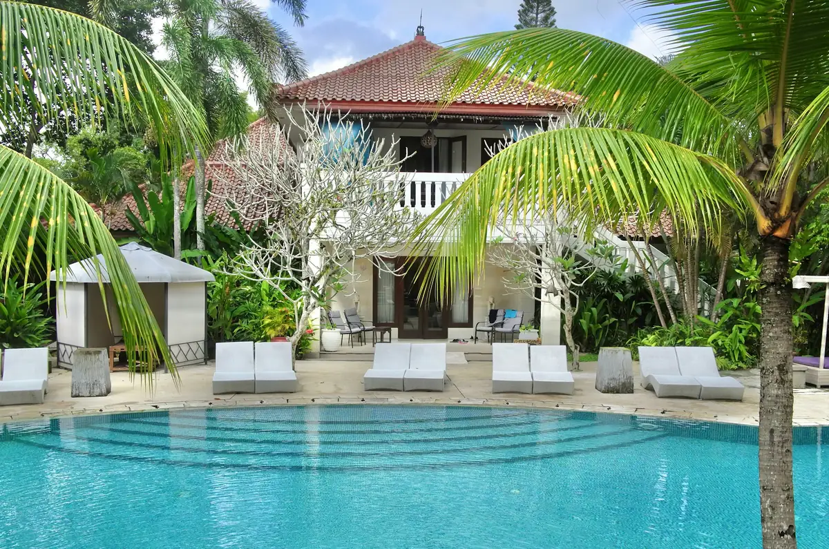 Tropical wellness resort pool surrounded by palm trees, Southeast Asia